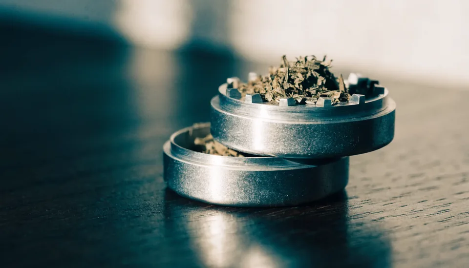 Geöffneter Aluminium-Grinder mit gemahlenem Kraut