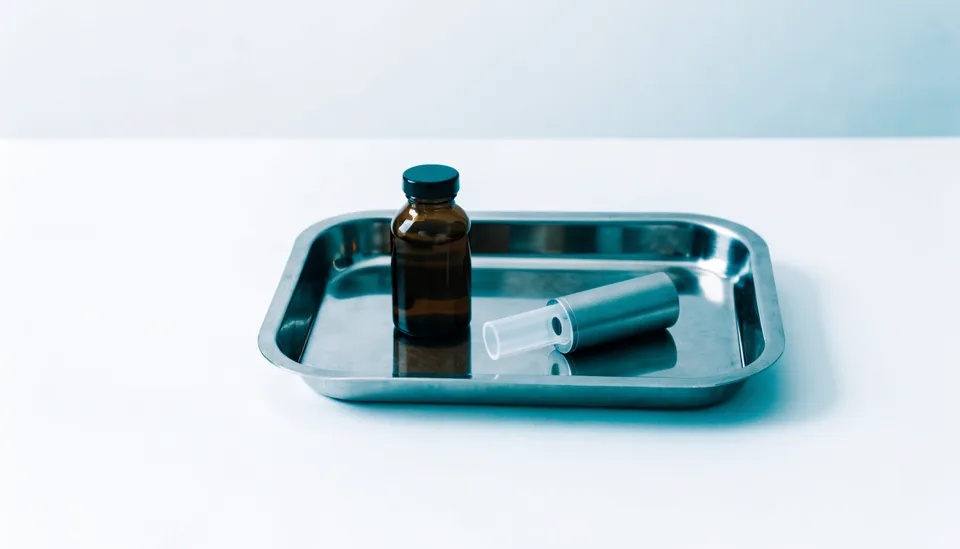 Klinisches Stillleben mit Edelstahlschale und Inhalationsgerät